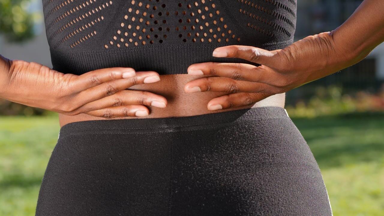 Person experiencing hip pain while holding their hip